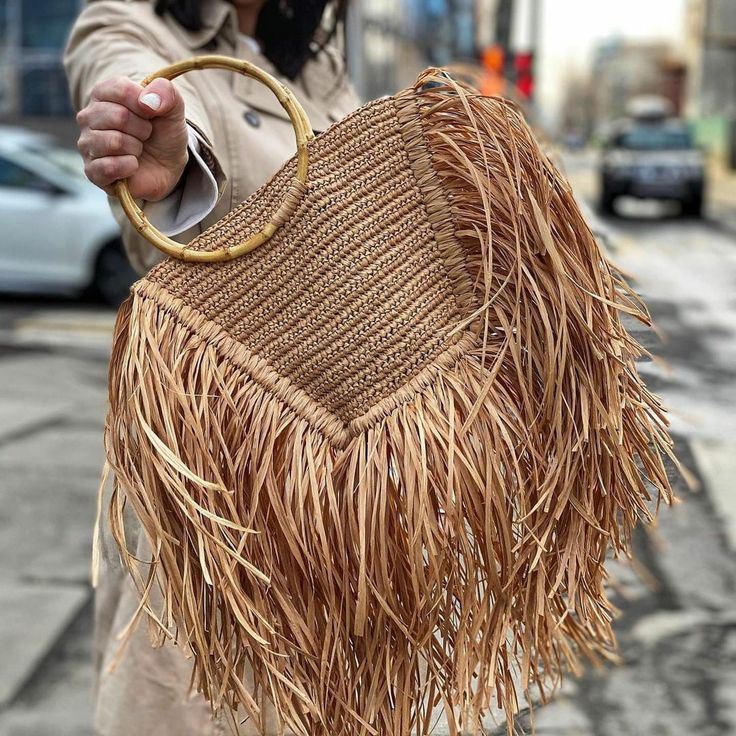Handmade straw bag with long fringes.