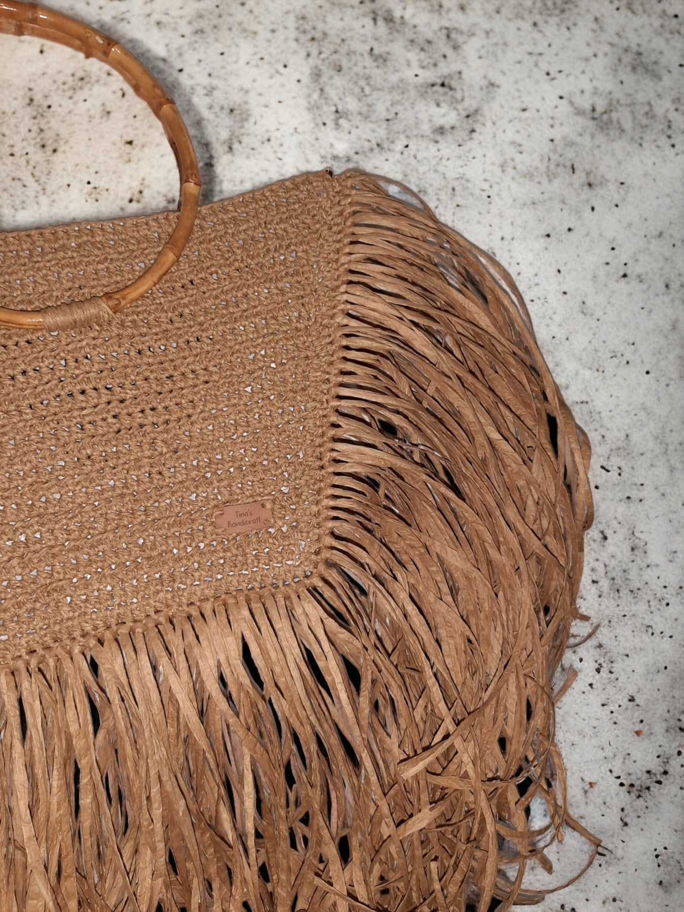 Handmade straw bag with long fringes.